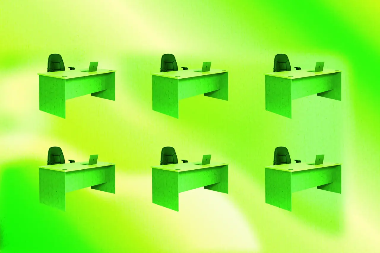 Six identical desks, each with an office chair and laptop, representing a growing staffing agency.